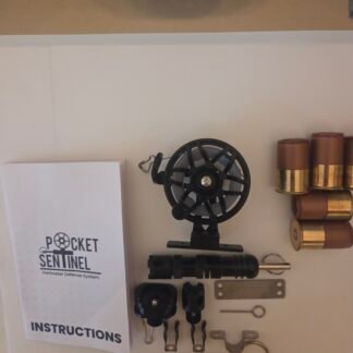 Pocket Sentinel perimeter defense system kit on a white surface, showing an instruction manual, a black spool, metal mounting brackets, clamps, and tubular components laid out neatly.